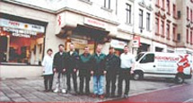 Chronik-Bild unserer Mitarbeiter vor einer ehemaligen Geschaeftsstelle